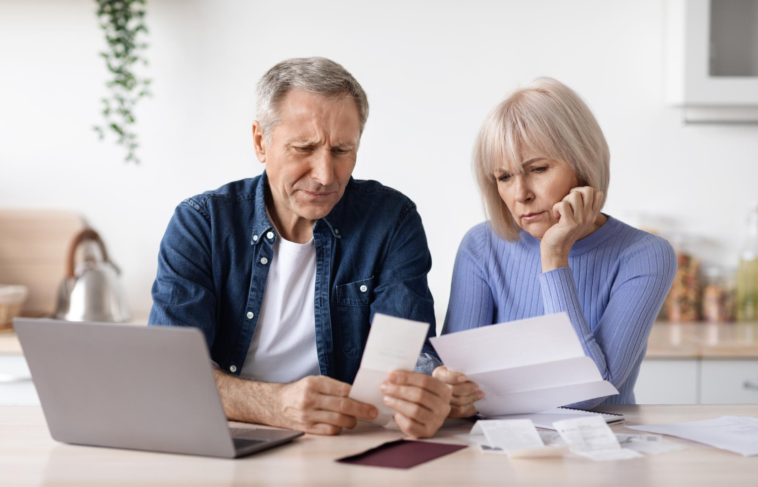 Senior Couple At Home With Bills Worried About Home Finances